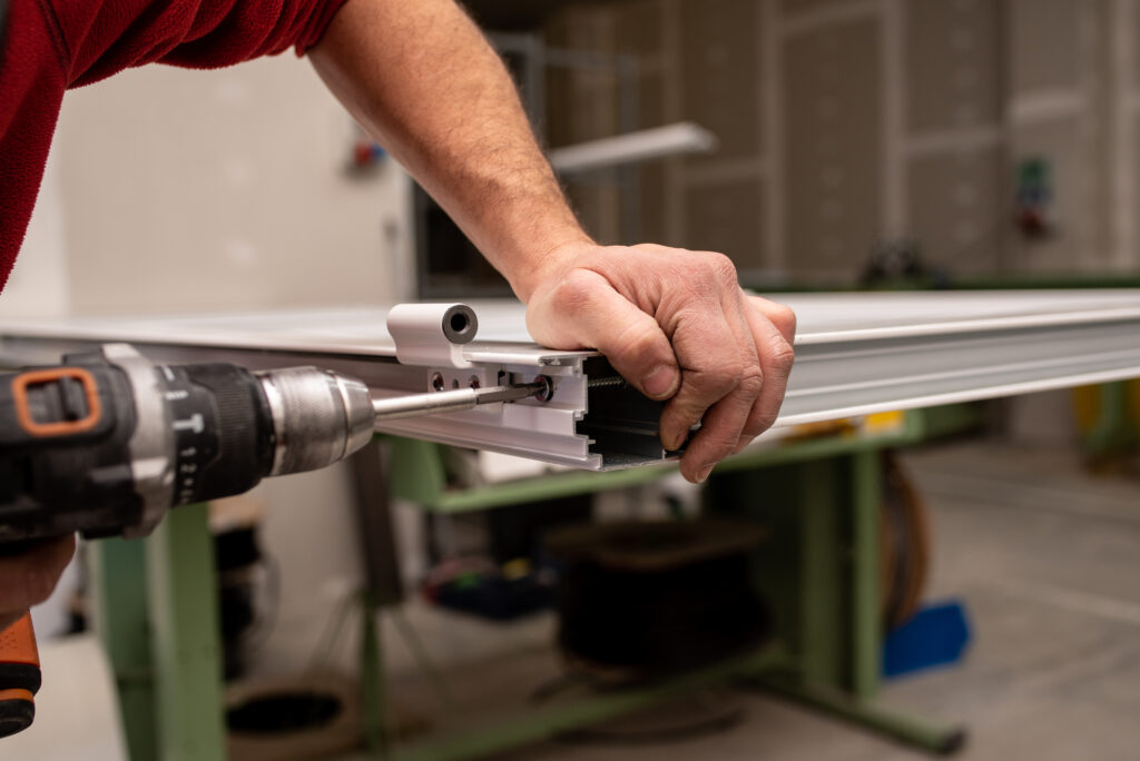 male with a red shirt making a window with industrial tools